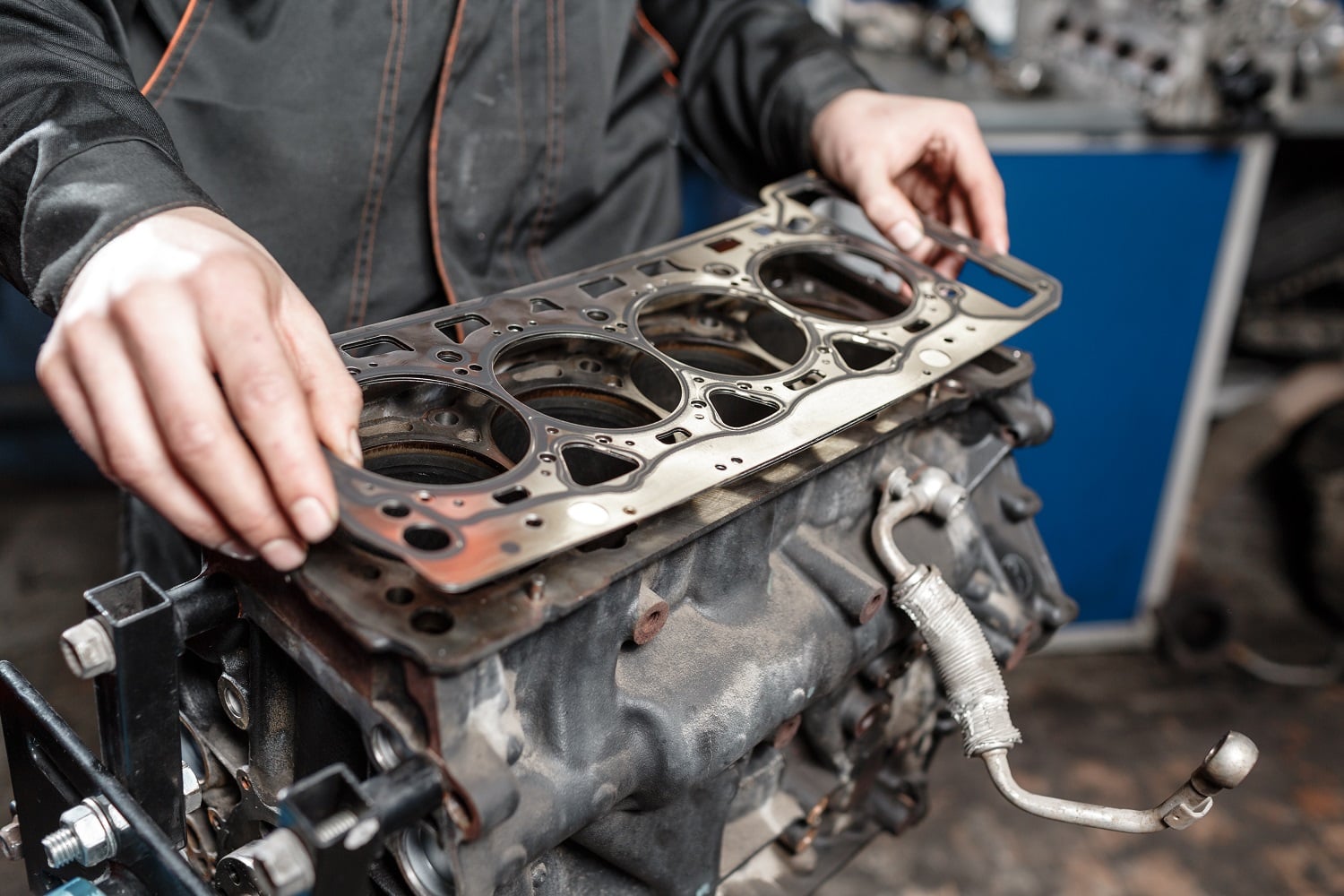 An image of a head gasket being placed on an engine block.